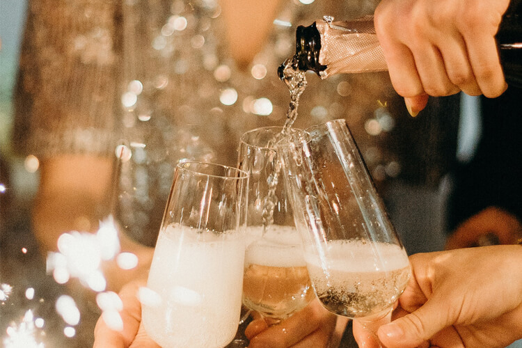 Champagne wordt ingeschonken in glazen.
